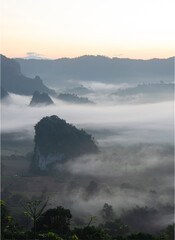 Morning mist covers the rice fields and mountains n Thailand
