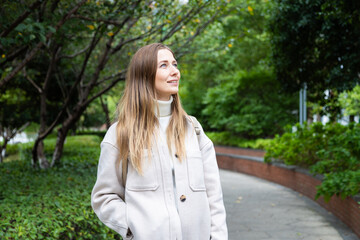Young woman walking through a park with a peaceful expression