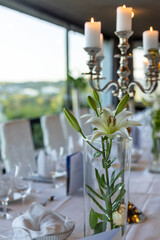 Elegant table setting with white flowers and candles for a special dinner event in a scenic location