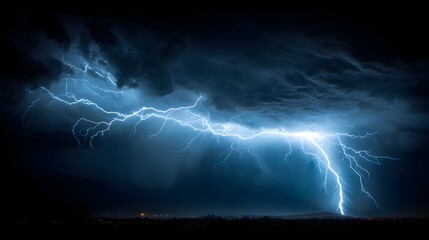 Brilliant jagged electrical discharge illuminates dark stormy night sky above distant horizon