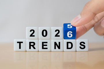 Hand flipping dice to change from 2025 to 2026 trends for business , fashion and technology trend change concept after new year.