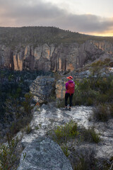 A woman stands on a pagoda overlooking a narrow ravine