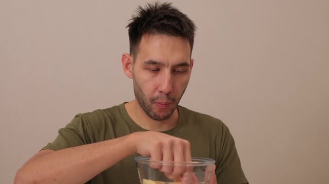 A man is happily enjoying a delightful snack from a bowl that is full of delicious treats