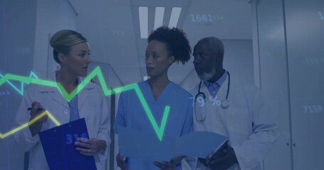 Medical team walking hospital corridor reading folder and displaying graphs for patient review