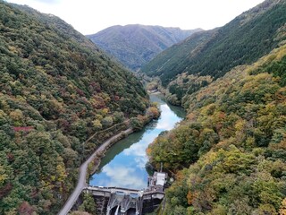 A beautiful mountain valley with a river running through it. The trees are full of leaves and the...