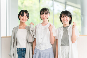 Elementary and junior high school girls in casual clothes with friends (fist pump)
