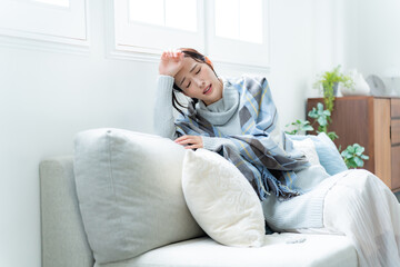 ソファで体調不良を訴える女性
