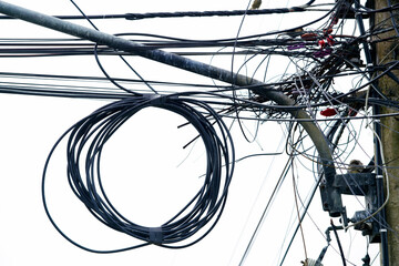 Tangle of Electric Wires and Cables on Utility Pole Against Sky