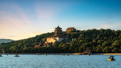 Scenic view of a traditional Chinese building by the lake at sunset