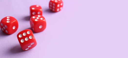 Red game dices on lilac background with space for text