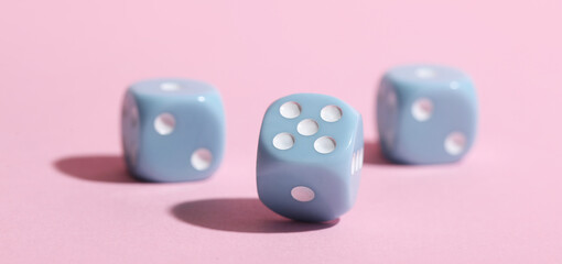 Game dices on pink background, closeup