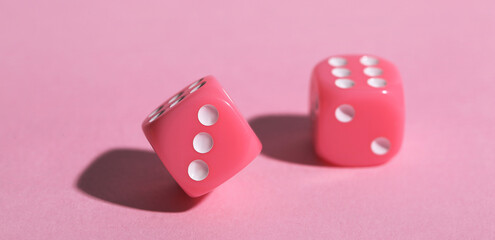 Game dices on pink background, closeup