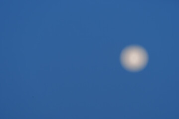 Circular moon high in sky on background with copy-space,