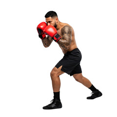 Muscular Hispanic male boxer with tattoos in a fighting stance, wearing red gloves and black shorts, ready for training or competition.