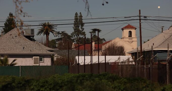 Shrubs frame a historic church in downtown Fowler, California, USA.