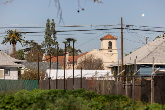 Shrubs frame a historic church in downtown Fowler, California, USA.