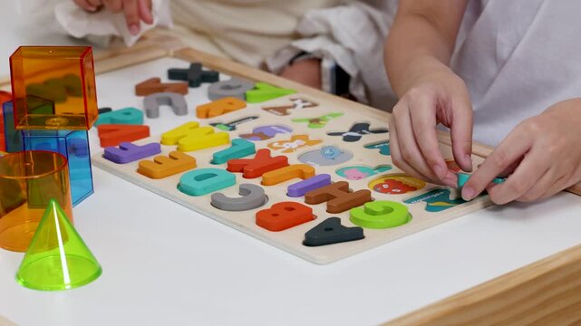 Children Playing Alphabet Puzzle Game on Wooden Table
