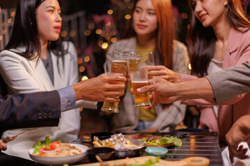 Happy Group of people Asian friends Drinking beer outdoors at the brewery for the New Year festival night time
people