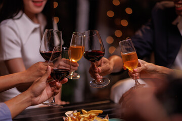 Group of people toasting with champagne glasses at a celebration. Hands holding champagne, clinking glasses. Festive atmosphere, joyful celebration, champagne toast. People toasting with champagne.
