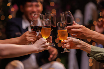 Group of people toasting with champagne glasses at a celebration. Hands holding champagne, clinking glasses. Festive atmosphere, joyful celebration, champagne toast. People toasting with champagne.
