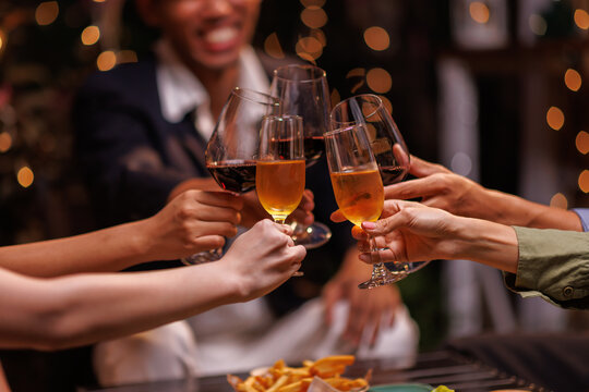 Group of people toasting with champagne glasses at a celebration. Hands holding champagne, clinking glasses. Festive atmosphere, joyful celebration, champagne toast. People toasting with champagne.
