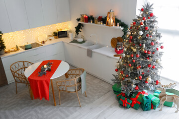 Interior of kitchen with counters, dining table and Christmas tree