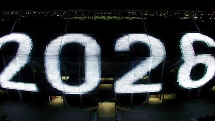 Giant illuminated 2026 on a stadium facade at night - Powered by Adobe