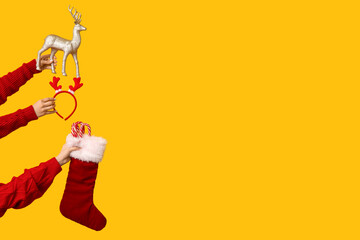 Female hands holding Christmas reindeer toy with Santa sock, candy canes and festive accessory on...