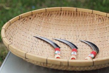 竹ざるに並べた稲刈り用の鎌