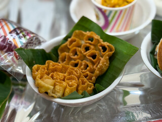 A bowl of fried food is sitting on a leafy green leaf
