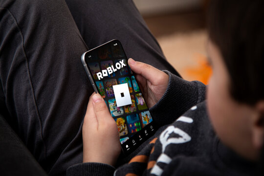 Little boy playing Roblox game on a mobile phone. Roblox is a very popular game among children and teenagers. Rosario, Argentina - October 28, 2025.