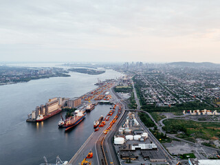 Obraz premium Aerial view of Montreal port with cargo containers, cranes and city skyline at sunset. g.