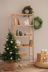 Interior of living room with shelf unit, Christmas tree and wreaths