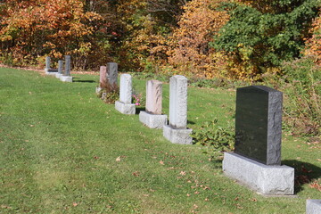 Naklejka premium Gravestones in a graveyard. Graves in cemetery and in autumn. God and religion. The death of someone and funeral. Gravestone design and memorial.