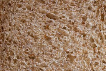 Wholesome macro background of brown bread texture, detailed close up of baked slice. This natural, rustic food provides perfect organic, culinary wallpaper for bakery