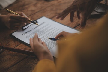 Business and lawyers discussing contract papers with brass scale on desk in office. Law, legal services, advice, justice and law concept picture with film grain effect