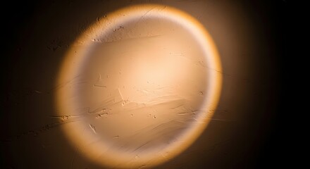 Close-up view of a circular, illuminated object with a textured surface and soft glow against a dark background