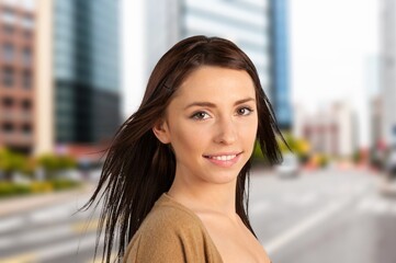Happy young girl smiling at city street.