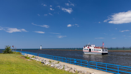 Tour Boat in Manistee river entering in to Lake Michigan on a sunny summer day.
