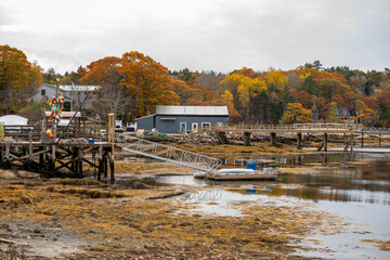 Rustic fishing dock decorated with colorful buoys and a small boathouse along the rocky shoreline...
