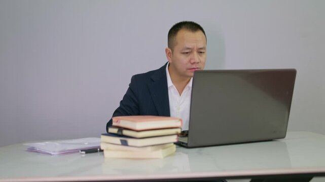 Suit man started massaging his eyes because he couldn't see the computer screen clearly. mature men who work in front of computers for long periods feel discomfort in their eyes. 