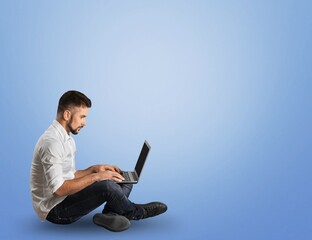 Confident businessman using laptop over blue background