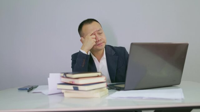 Office men face work problems and don't know what to do. Suit man flips through documents at work without any idea how to proceed. Mature man encounters work difficulties and is thinking