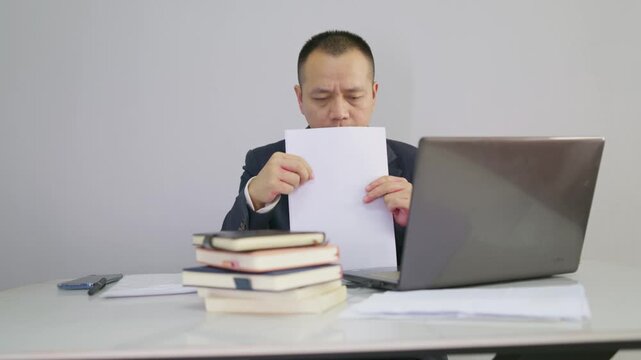 Office men face work problems and don't know what to do. Suit man flips through documents at work without any idea how to proceed. Mature man encounters work difficulties and is thinking about how to 