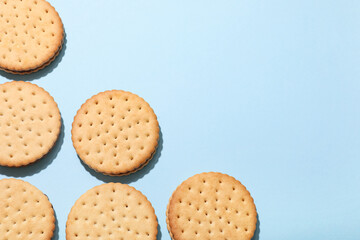 Tasty sandwich biscuits with chocolate cream on blue background