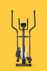 Modern exercising bike on yellow background