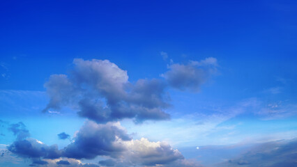 Obraz premium Clear blue sky with fluffy white clouds on a bright sunny day