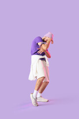 Male hip-hop dancer on lilac background