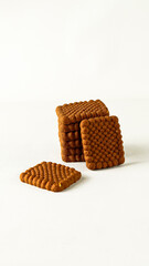 Stack of delicious crispy biscuits with chocolate flavor in square shape on a white background
