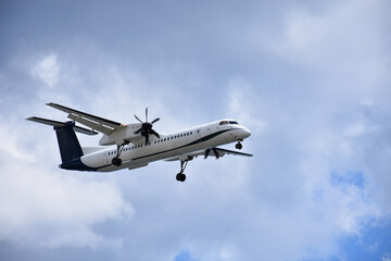 Turboprop passenger aircraft landing on a runway, captured in motion during descent.